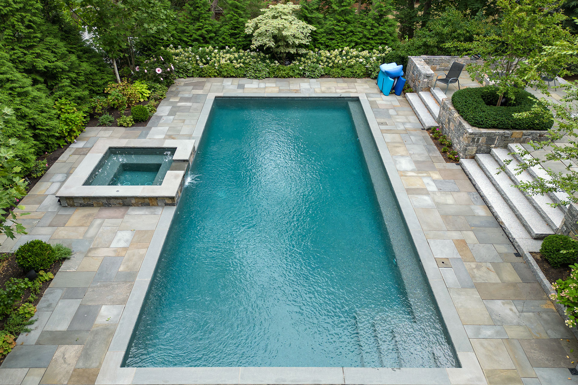 Refined pool deck and terrace material beside a custom pool